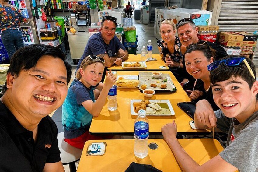 A group of people sitting at a table with food and drinks. 4