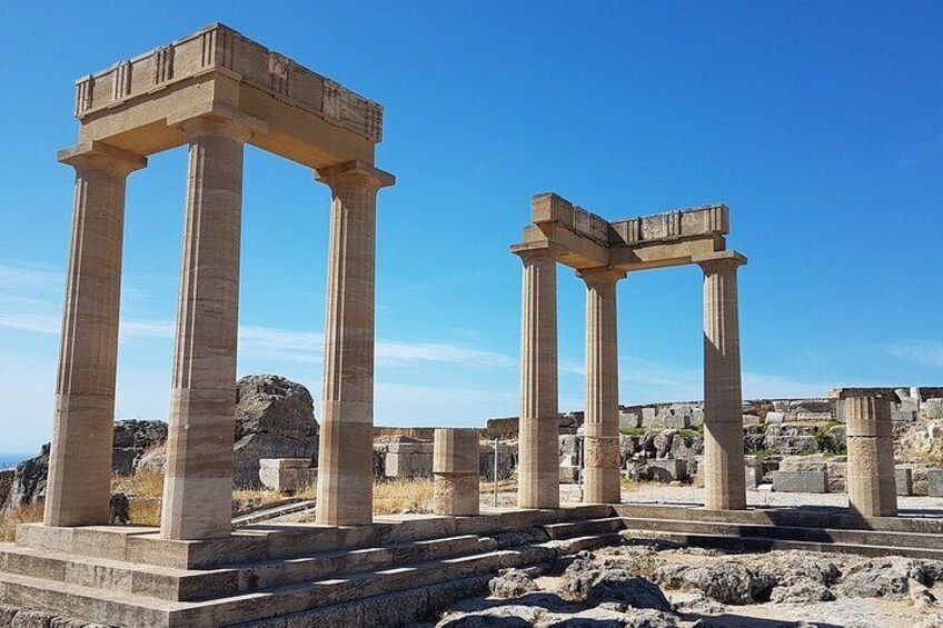 Ancient Greek columns with a clear blue sky in the background. 3