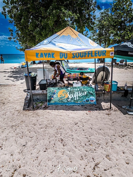 A beachside kayak rental service named 'KAYAK DU SOUFFLEUR' with a signboard and equipment. 2