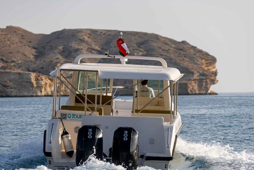 A boat with a flag, moving on water with rocky cliffs in the background. 2