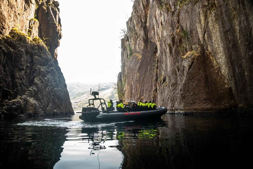 A boat navigating through a narrow canyon with steep rock walls. 5