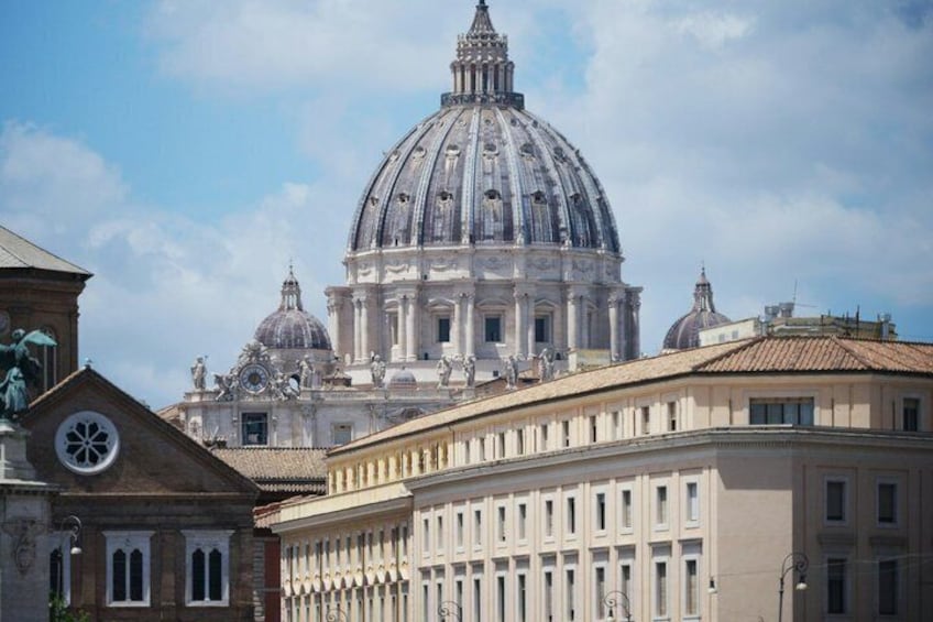A large domed building with classical architecture, a clock tower, and a clear sky. 2