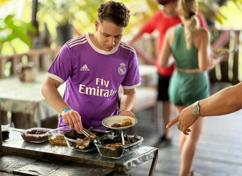A person serving food from a bowl. 1