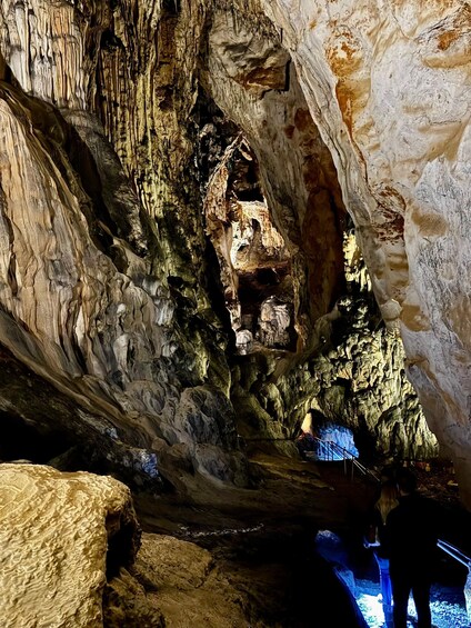 A cave interior with stalactites, stalagmites, and a blue-lit water feature. 4