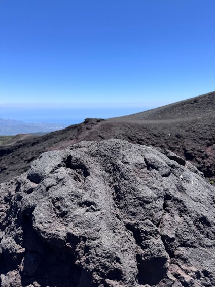A volcanic rock formation with a clear sky in the background. 3