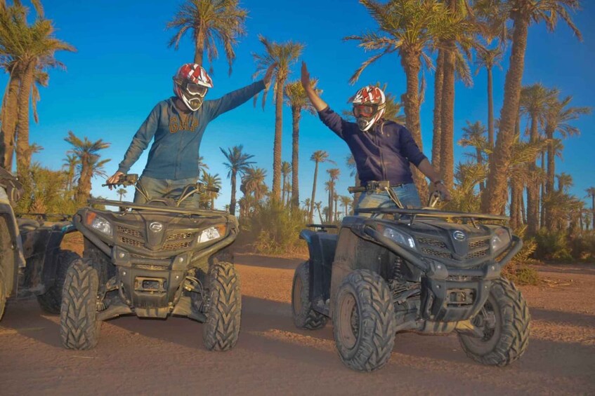 Two people on ATVs in a desert with palm trees. 3