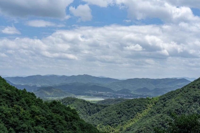 A mountainous landscape with dense forests and a valley in the distance. 3