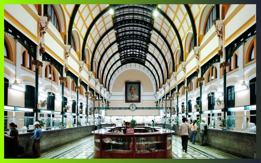 An indoor atrium with a high arched ceiling, a central display case, and people walking. 2