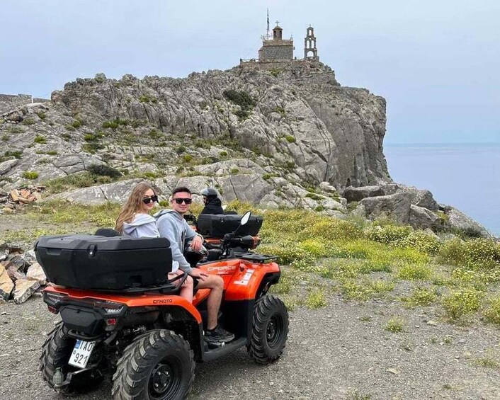 A couple on an ATV near a rocky cliff with a bell tower. 5