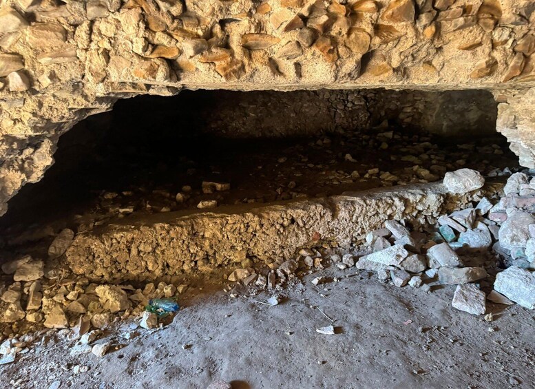 A cave entrance with rocky walls and a dirt floor. 4