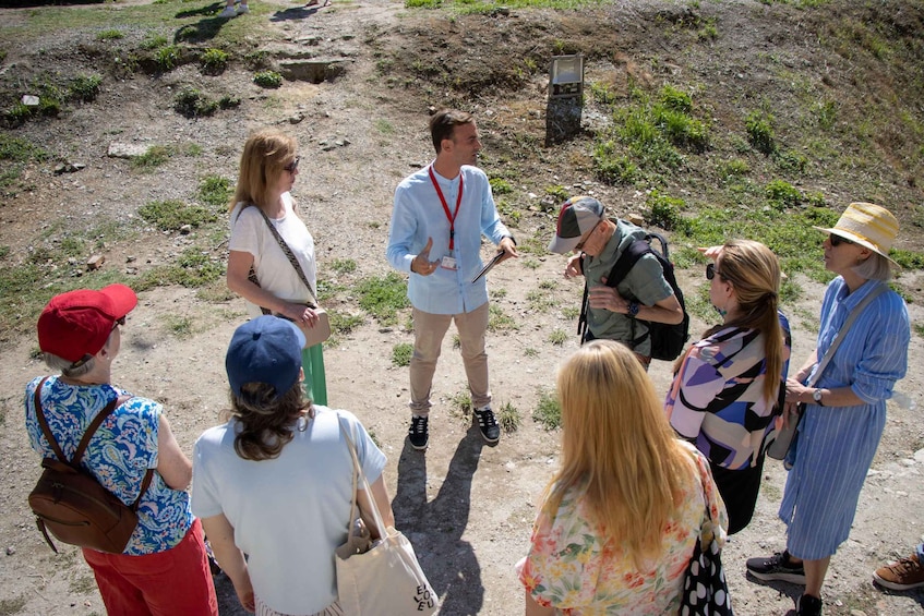 A group of people standing on a dirt path in a natural setting. 1