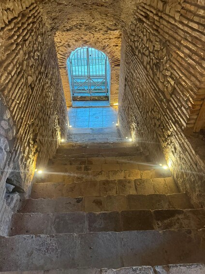 A stone staircase leading to a window with a metal gate. 2