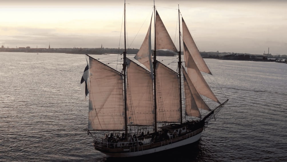 A sailing ship with multiple sails on calm water. 2