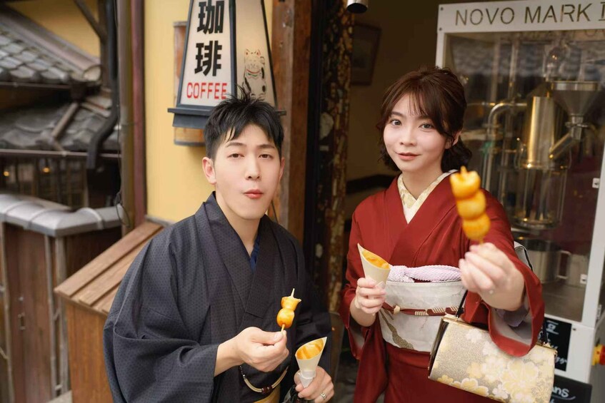 Two people holding skewers of food in front of a coffee shop. 4