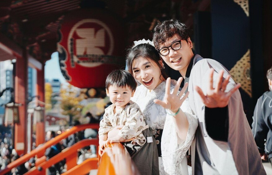 A family at a traditional Japanese shrine with a red torii gate in the background. 1