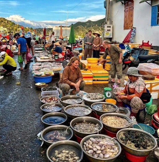 A bustling outdoor market with vendors selling seafood. 4
