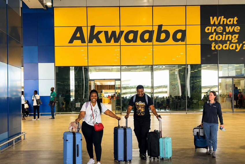 A group of people with luggage at an airport, with a sign reading 'Akwaaba' and a question 'What are we doing today?' 2