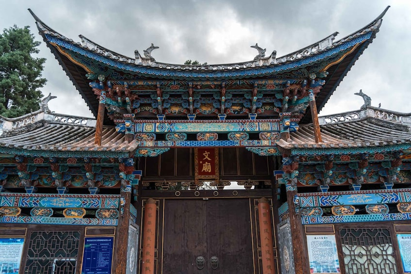 A traditional Chinese gate with ornate decorations and a blue and gold roof. 1