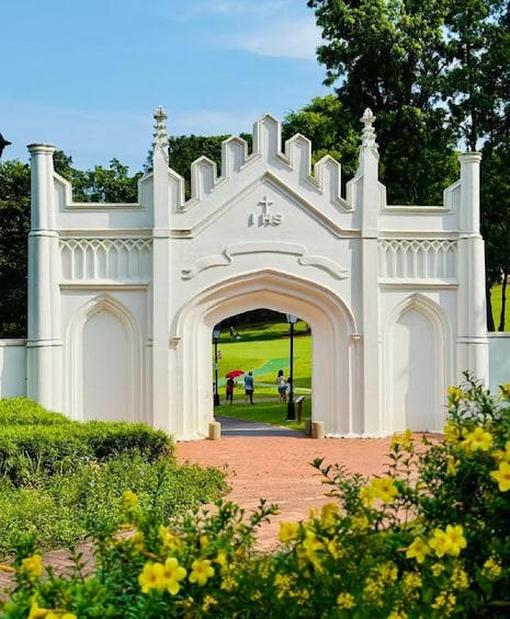 A white gate with a cross, leading to a grassy area. 1