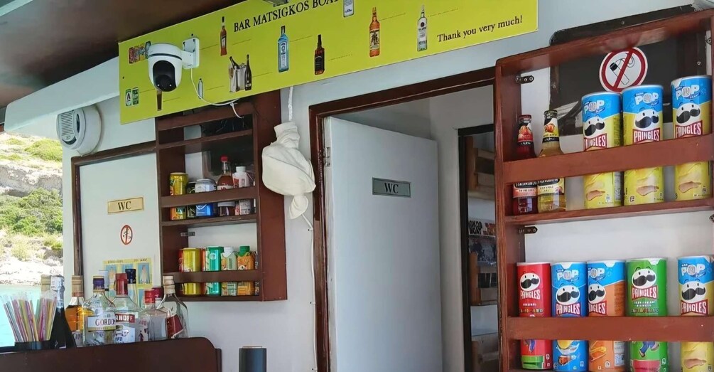 A bar with shelves of canned drinks and a sign for the WC. 5
