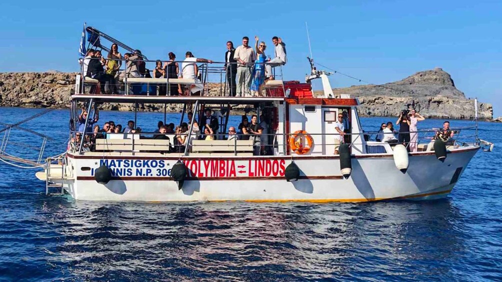 A boat named 'Matsigkos' with passengers on board, sailing on the water. 5