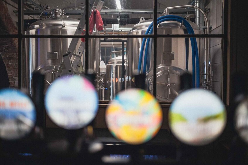 Industrial brewing equipment, stainless steel tanks, and blue hoses in a facility. 4