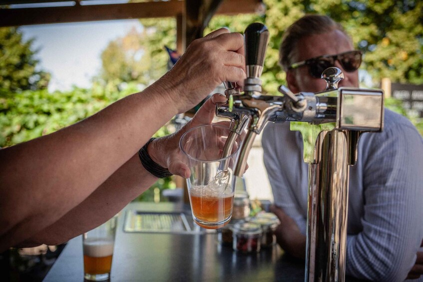 A person pouring beer from a tap into a glass. 3