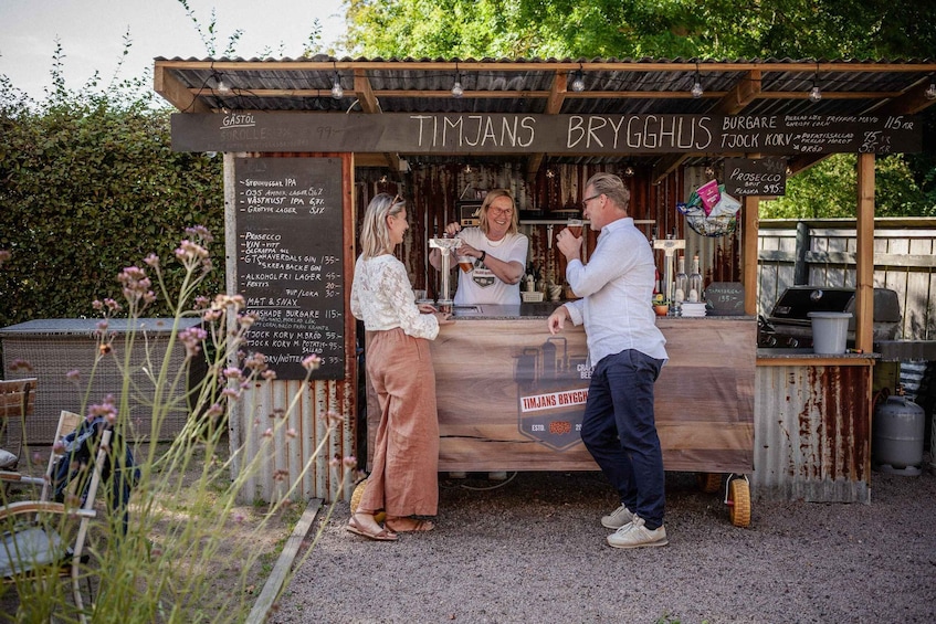A food stall named 'TIMJANS BRYGGHUS' with a menu board listing items like 'Stubbhuus IPA' and 'Västra Hus IPA.' 1