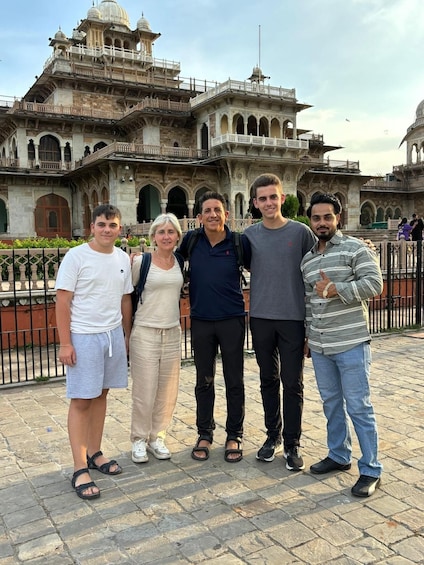 A group of people standing in front of a historic building with intricate architecture. 2