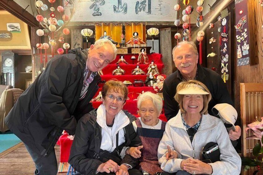 A group of people in a traditional setting with red decorations and cultural artifacts. 4