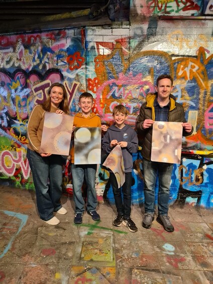 A group of people standing in front of a colorful graffiti wall. 5
