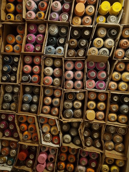 A collection of spray paint cans in cardboard boxes. 2