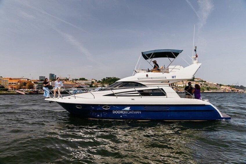 A yacht named 'DouradoMan' on water with a cityscape in the background. 3