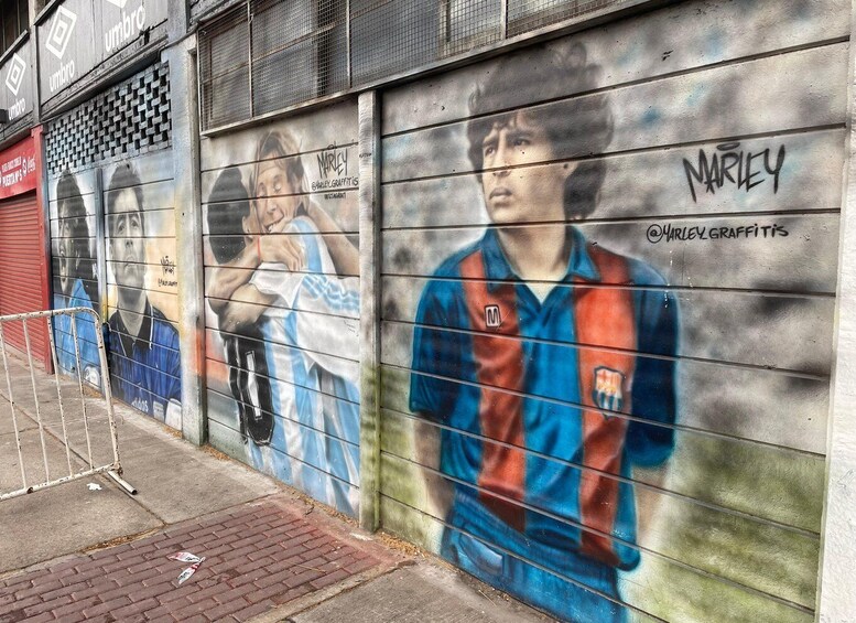 A mural of a soccer player on a wall with graffiti tags. 5