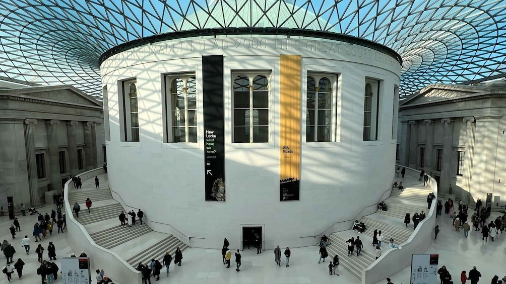 A grand building with a glass dome and multiple staircases. 2