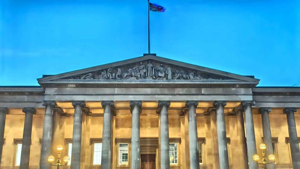 A neoclassical building with a central pediment, columns, and a flag. 3