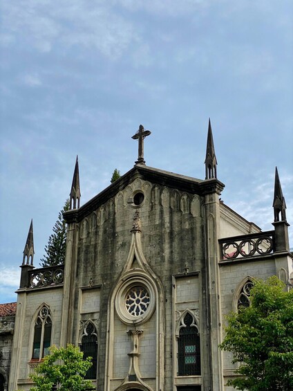 A Gothic-style church with a prominent cross, pointed spires, and a rose window. 3