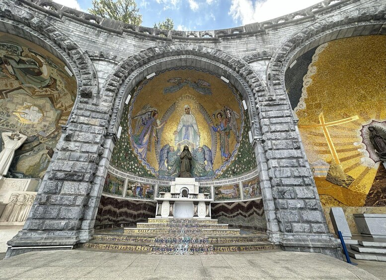 A historic church interior with ornate mosaics and a central statue. 4