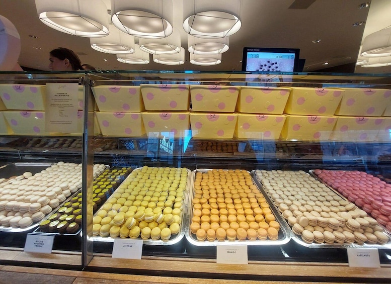 A display case with various macarons in different colors and flavors, labeled with their names. 4