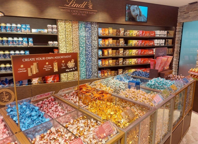 A Lindt chocolate shop with a variety of chocolates displayed in glass cases and on shelves. 5