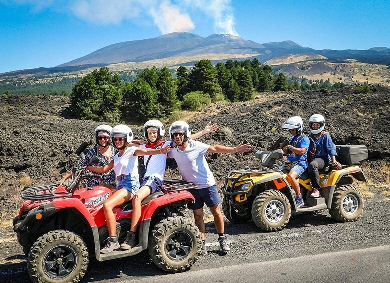 A group of people on ATVs with a volcano in the background. 1