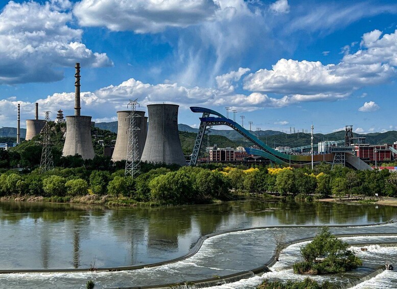 A power plant with cooling towers and a roller coaster. 1