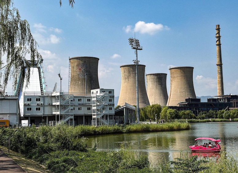 A nuclear power plant with cooling towers and a river with a pink boat. 3
