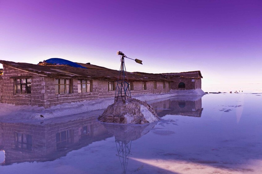 A frozen lake with a building and a windmill in the foreground. 1