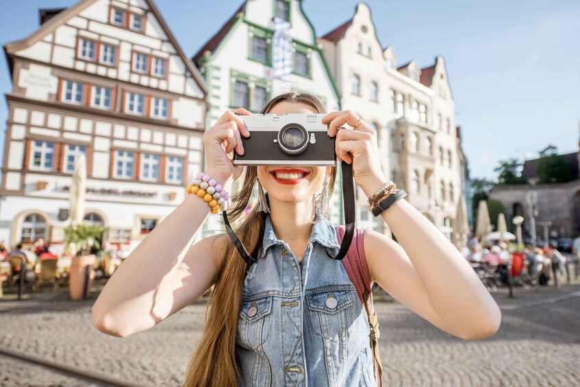 A person holding a camera with traditional architecture in the background. 5