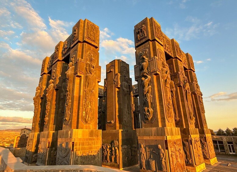 A large, intricately carved stone monument with multiple columns and relief sculptures. 5