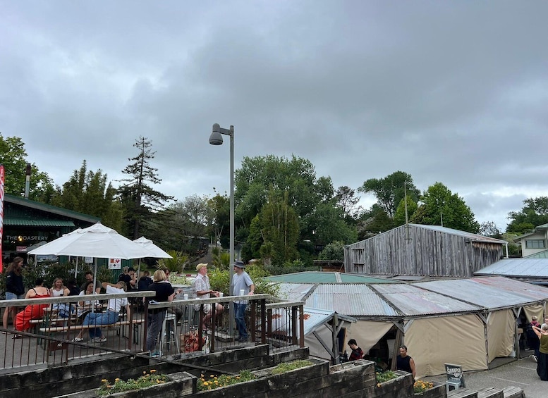 A public outdoor area with a café, tents, and a rustic building. 2