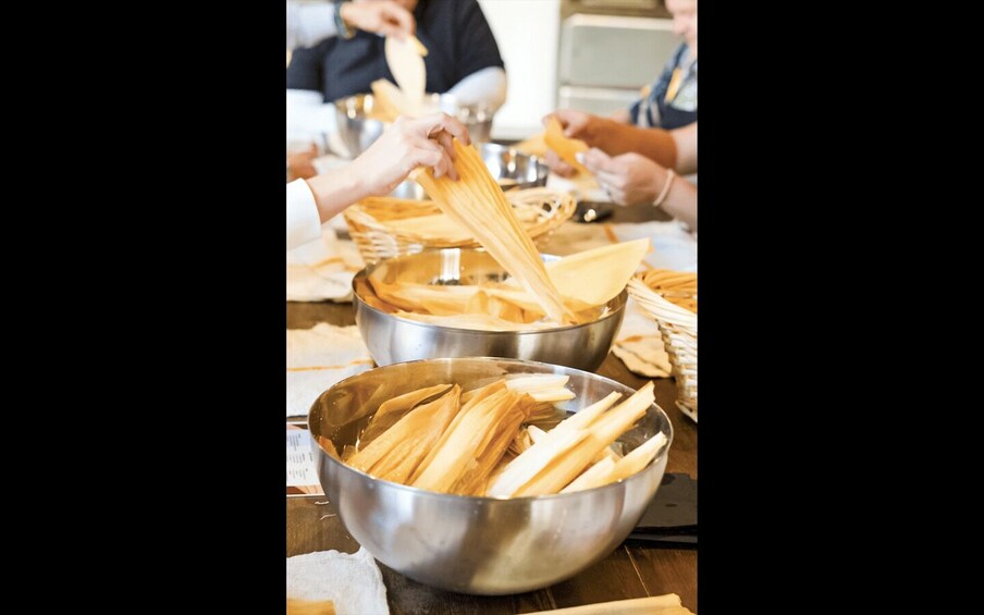 People preparing tamales at a communal table. 5