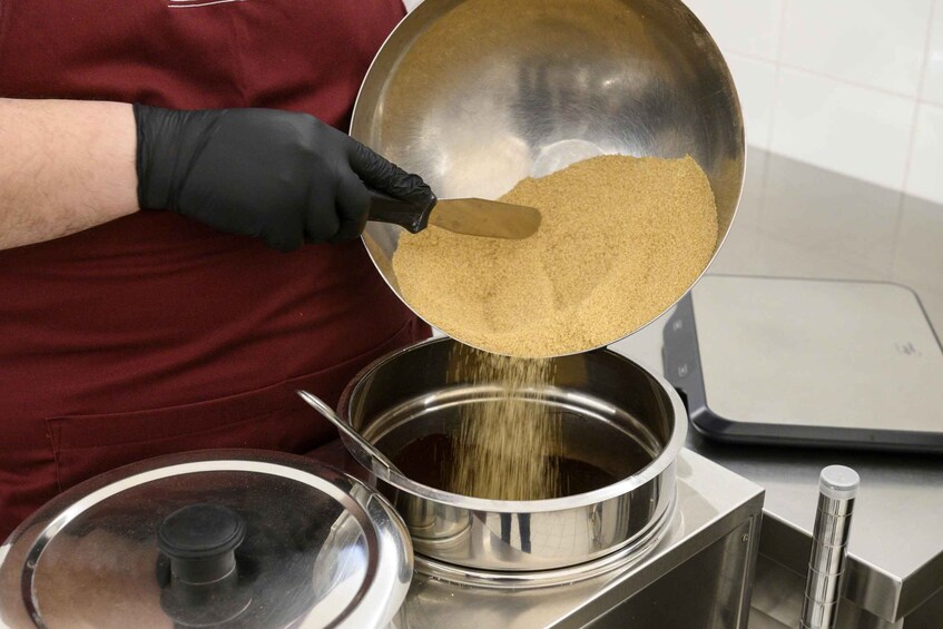 A person pouring a granular substance into a pot. 4