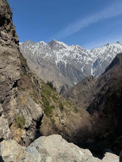 A rugged mountain landscape with snow-capped peaks and rocky terrain. 2